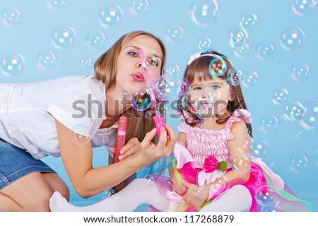 Mother teaches daughter blow bubbles