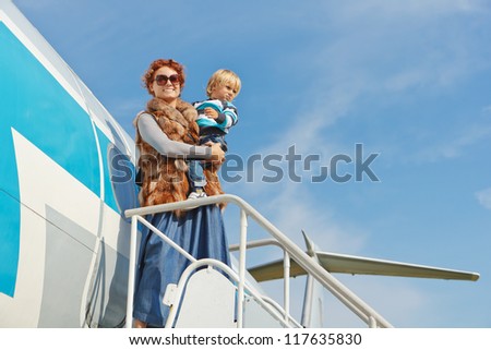 Mother and little son traveling by airplane
