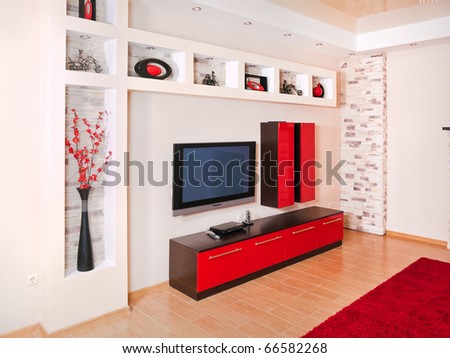 Beige and red interior of modern house with flat TV set