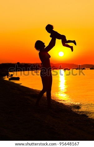 Happy family resting at beach in sunset, summertime