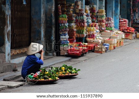 Street vendor in Vietnam selling fruit at a corner in Hanoi.