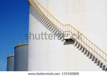 White chemical storage tank with spiral stairs.