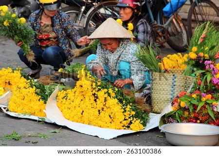 HOI AN, VIETNAM - MARCH 19, 2015: A Flower vendor selling fresh flowers at local market in Hoi An.