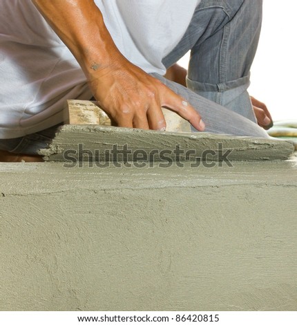 Closeup mason  hand spreading fresh concrete mix with trowel