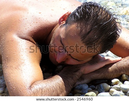 man sunbathing, laying on beach