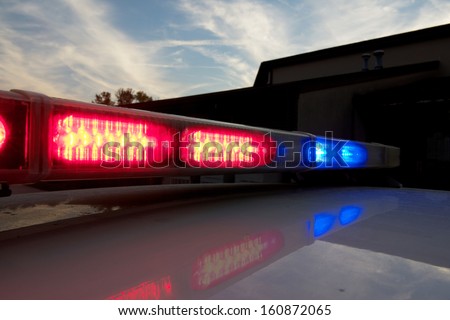 Strobelight bar on top of police car flashing red and blue.