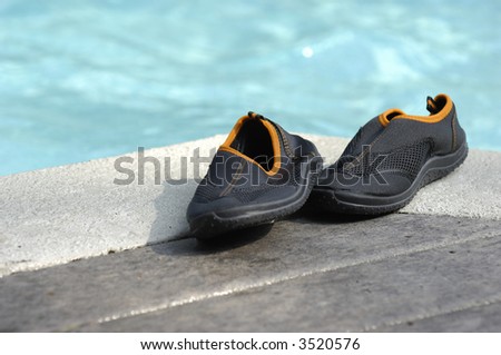Youth swim shoes next to pool