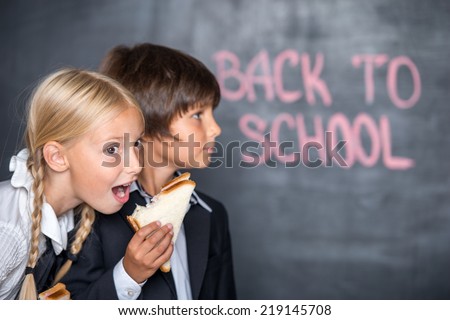 Funny picture of school boy and girl with sandwiches