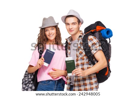 Happy young couple of tourists smiling and  holding passports