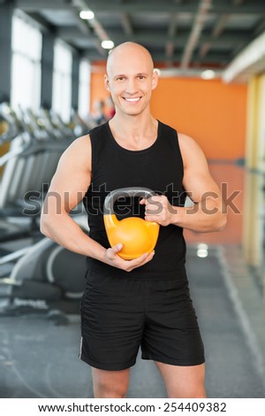 Strong guy at the gym lifting weights
