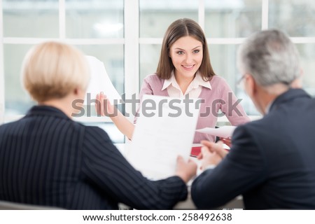 Young woman having an interview or business meeting with employers. Office interior with big window