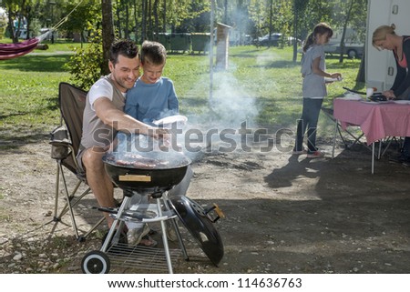 Father and son cooking in front of mobile van