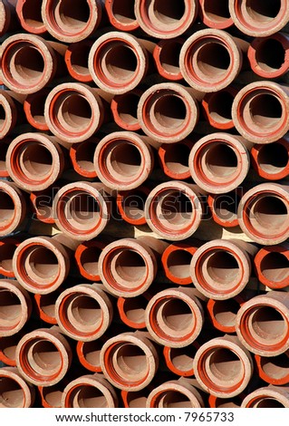 Repetitive stack of clay pipes on construction site