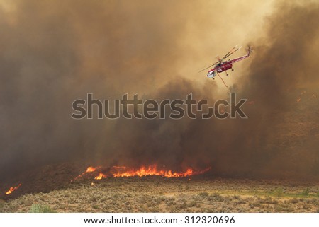 Riverside, WA, USA August 18, 2015: Okanogan Complex Fire. A helicopter negotiates its way thru heavy smoke to help fight Washington state\'s largest and most destructive fire in history