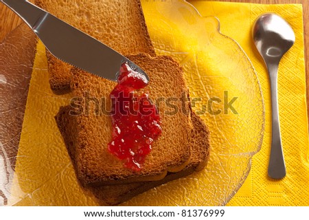 breakfast on a wooden table with strawberry marmalade and toasted bread
