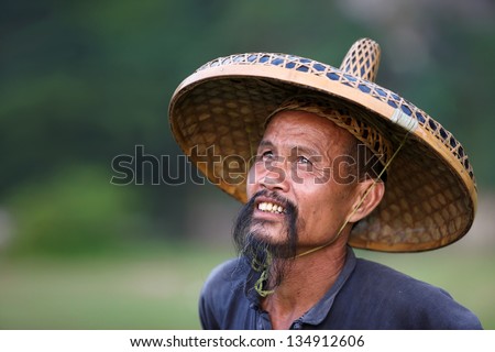 GUANGXI - JUNE 18: Chinese man in old hat in Guangxi region, traditional type of man face in China, June 18, 2012 in Guangxi, China. The average life expectancy among Chinese men is 72 years