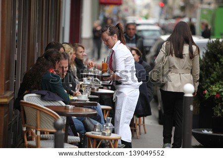 PARIS - APRIL 27 : Parisians and tourist enjoy eat and drinks in cafe sidewalk in Paris, France on April 27, 2013. Paris is one of the most populated metropolitan areas in Europe.