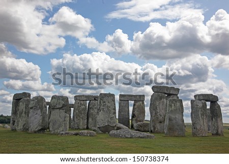 Stonehenge historic site on green grass under blue sky. Stonehenge is a UNESCO world heritage site in England with origins estimated at 3,000BC