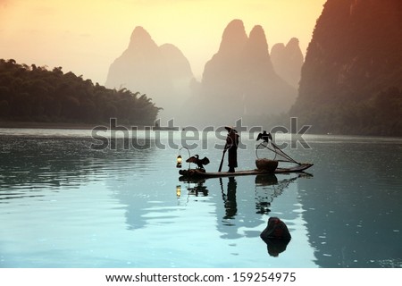 Chinese man fishing with cormorants birds in Yangshuo, China