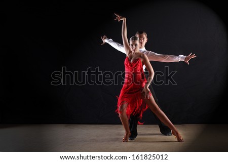 Latino Dancers In Ballroom Against Black Background
