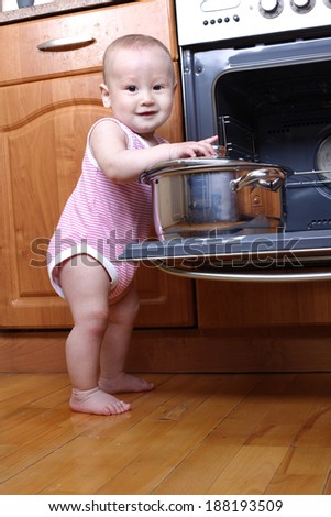 Child 1 year old in the kitchen cooking breakfast