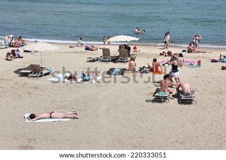 BARCELONA - JUNE 11: At the beach with tourists and locals in summer on June 11, 2013 in Barcelona, Spain. Barcelona is a famous destination for hundred of thousands of tourists a year