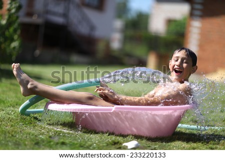 boy with splash water in hot summer day outdoors