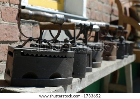 Antique rusty flatirons on coal