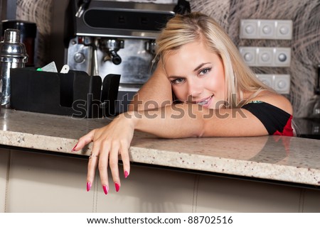 Lovely smiling blond woman at bar table