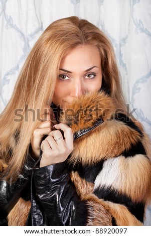 Elegant young brunette woman in stylish fur coat