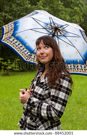 Young woman with umbrella under the rain on the nature