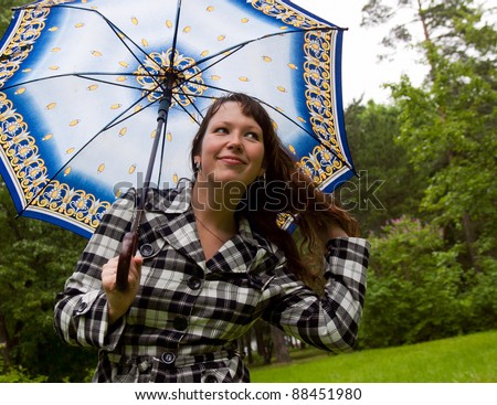 Young woman with umbrella under the rain on the nature