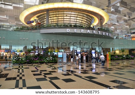 SINGAPORE - JUNE 14: Visitors walk toward the departure gate in Changi Airport on June 14, 2013 in Singapore. Singapore airport is  handling 66 million passengers per year.