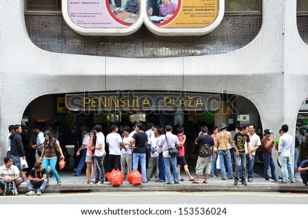 SINGAPORE - SEPTEMBER 08: Foreign workers gather in front of Peninsula Plaza on September 08, 2013 in Singapore. Peninsula Plaza bulges with local Burmese residents who gather in groups to socialise.