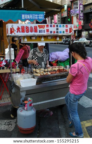 TAIPEI, TAIWAN-JUNE 14: Customer buys street food from street vendor on June 14, 2013 in Taipei, Taiwan. There are over 100 night markets scattered throughout the city.
