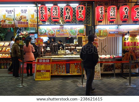 OSAKA, JAPAN - DECEMBER 13: Unidentified customers queue to buy takoyaki in Osaka on December 13, 2014. Takoyaki is one of the most famous food in Osaka, Japan