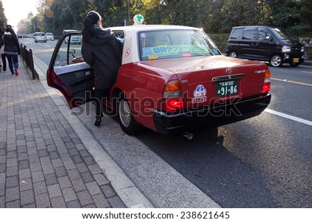 KYOTO, JAPAN - DEC 9: Passager get in a taxi in Kyoto on December 09, 2014. Japanese taxi for international tourist can be found either at Kyoto station or specific spots around Kyoto city