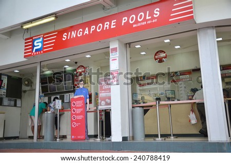 SINGAPORE - OCTOBER 26: Customers buy lottery tickets in Singapore Pools shop on October 26, 2014. Singapore Pools is the only legal lottery operator in Singapore.