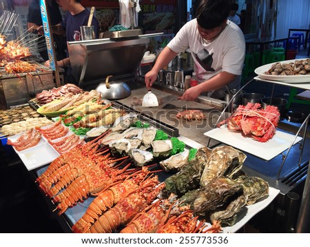 KAOHSIUNG, TAIWAN - NOV 27: Chief prepares seafood to be sold in Kaohsiung night market on November 27, 2014. People enjoy food at night market in Taiwan. And is one of the unique culture in Taiwan.