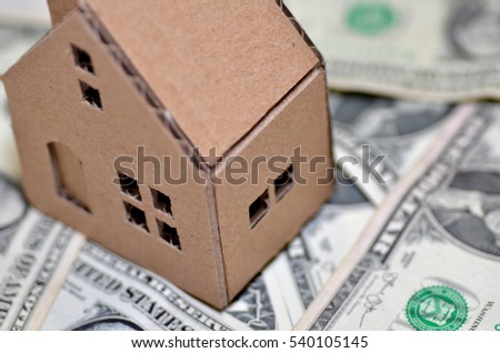 Paper made house stands on dollar money