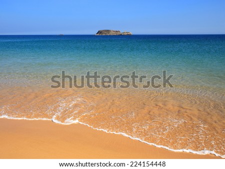 Portugal, Algarve, Sagres, beautiful turquoise Atlantic Ocean with crystal clear water washing onto a deserted Martinhal Beach with powdery sand. Clear horizon. Blue sky.