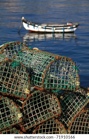 Portugal Lisbon\'s Sunshine Coast Bay of Cascais - fishing traps with typical coastal fishing boat in background