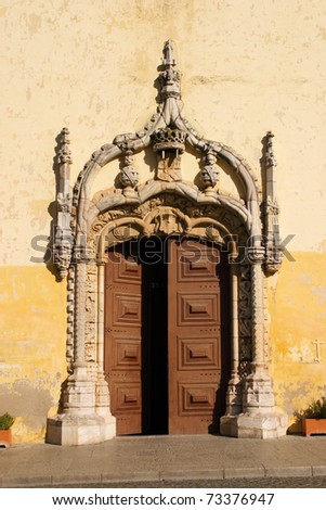 Portugal, Alentejo Region, beautiful intricately sculpted stone Manueline door arch and wooden door - church facade