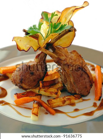Lamb chops with Portuguese sweet potato chips and glazed carrots on white background