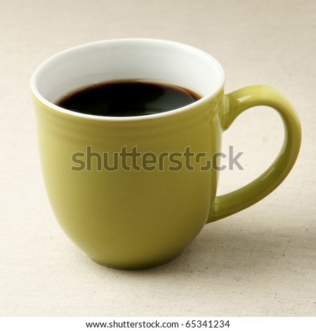 Green coffee mug on rustic table cloth