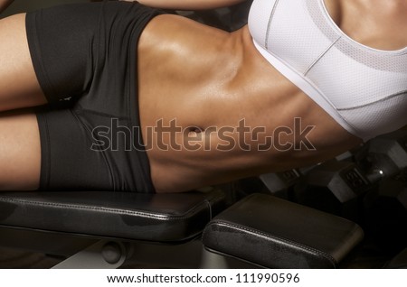 Image of well toned athletic young woman with tight defined abs in stomach