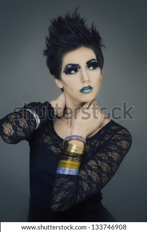 Beautiful fashion model with flawless porcelain skin, short spiky hair, creative makeup and cosmetics.