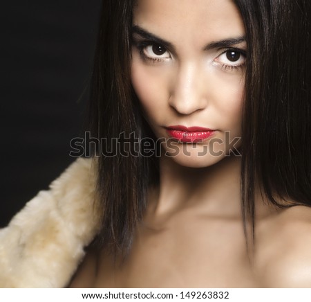 Beautiful elegant sensual woman's face holding fur.