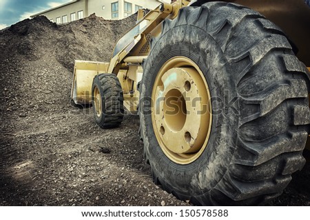 Bull dozer heavy duty construction site focus on large tire.