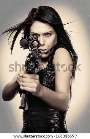 Beautiful young woman poking through scope of army rife